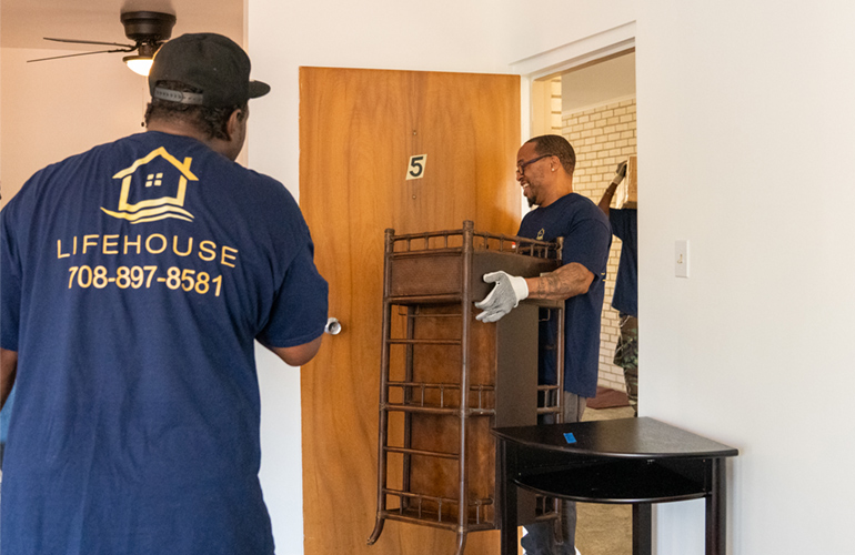 Men move furniture in an apartment